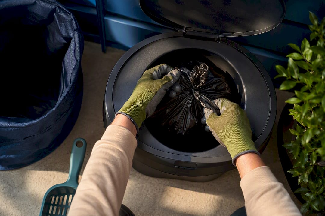 Tied dog waste bag secured in bin